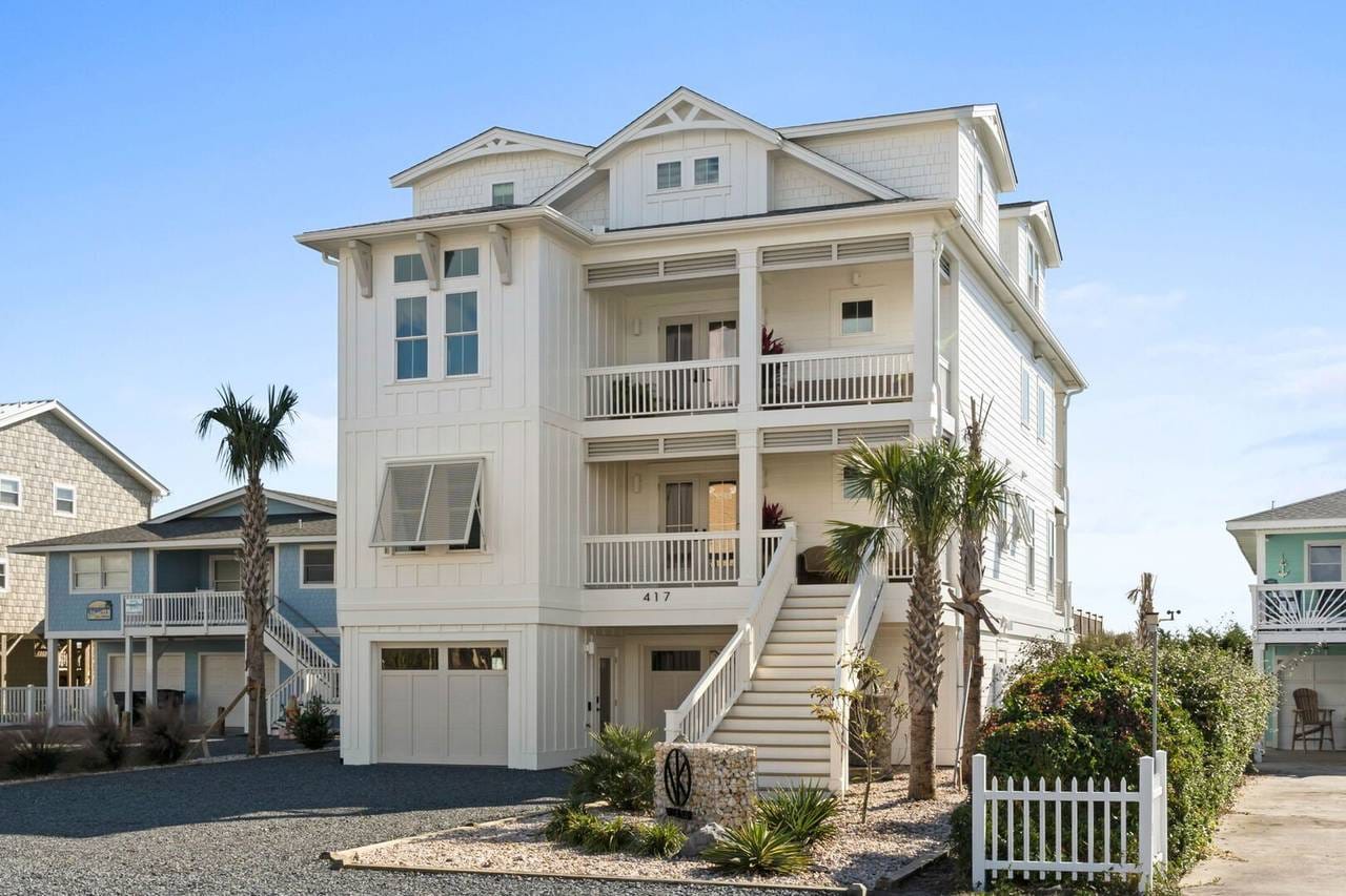 Three-story coastal house with balcony.