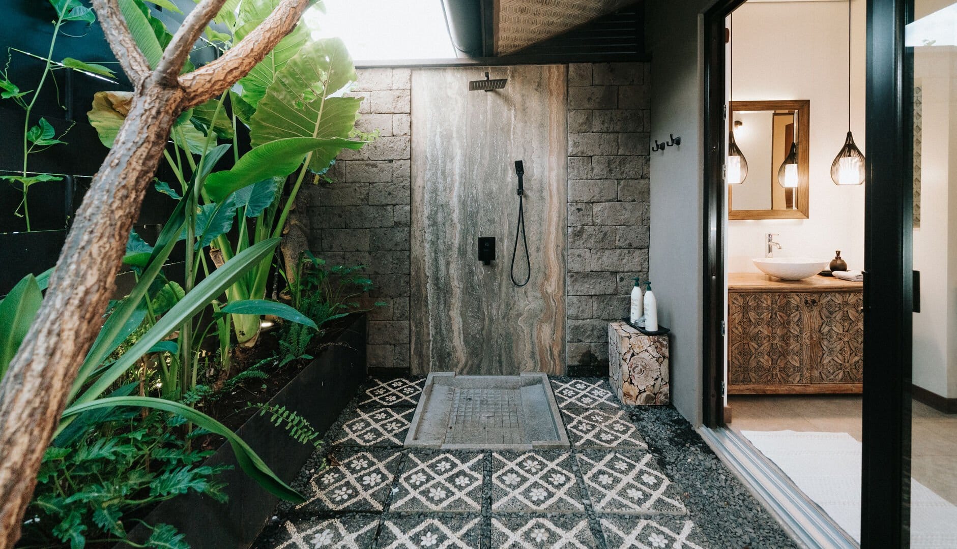Outdoor shower with lush plants.
