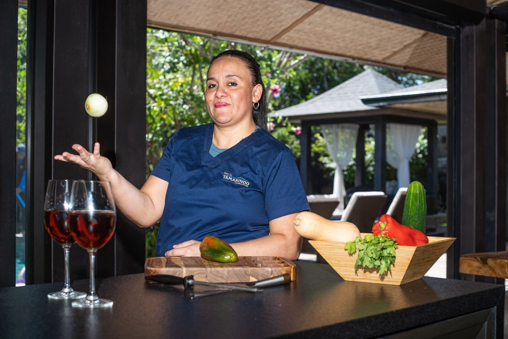 Chef juggling produce in kitchen.