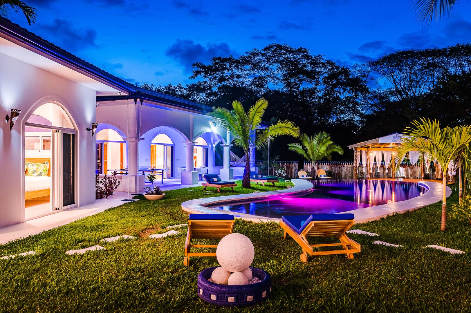Luxury villa with illuminated pool.