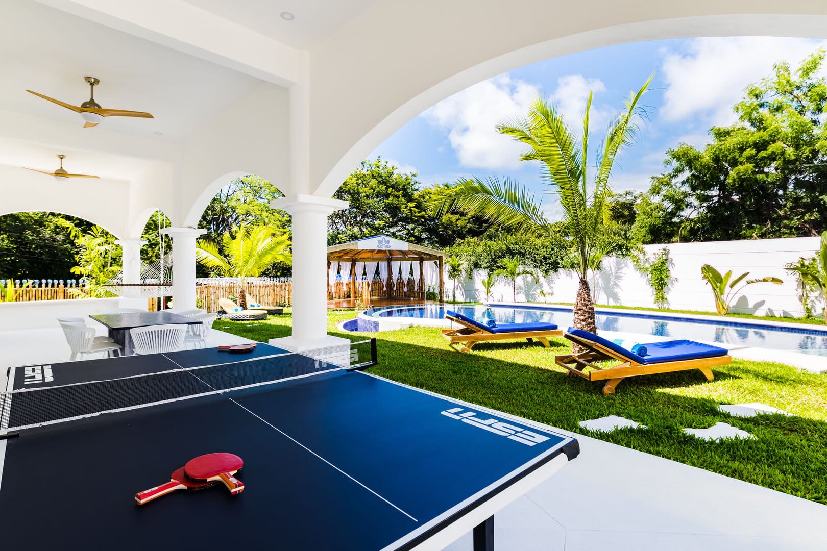 Outdoor patio with pool and ping pong.