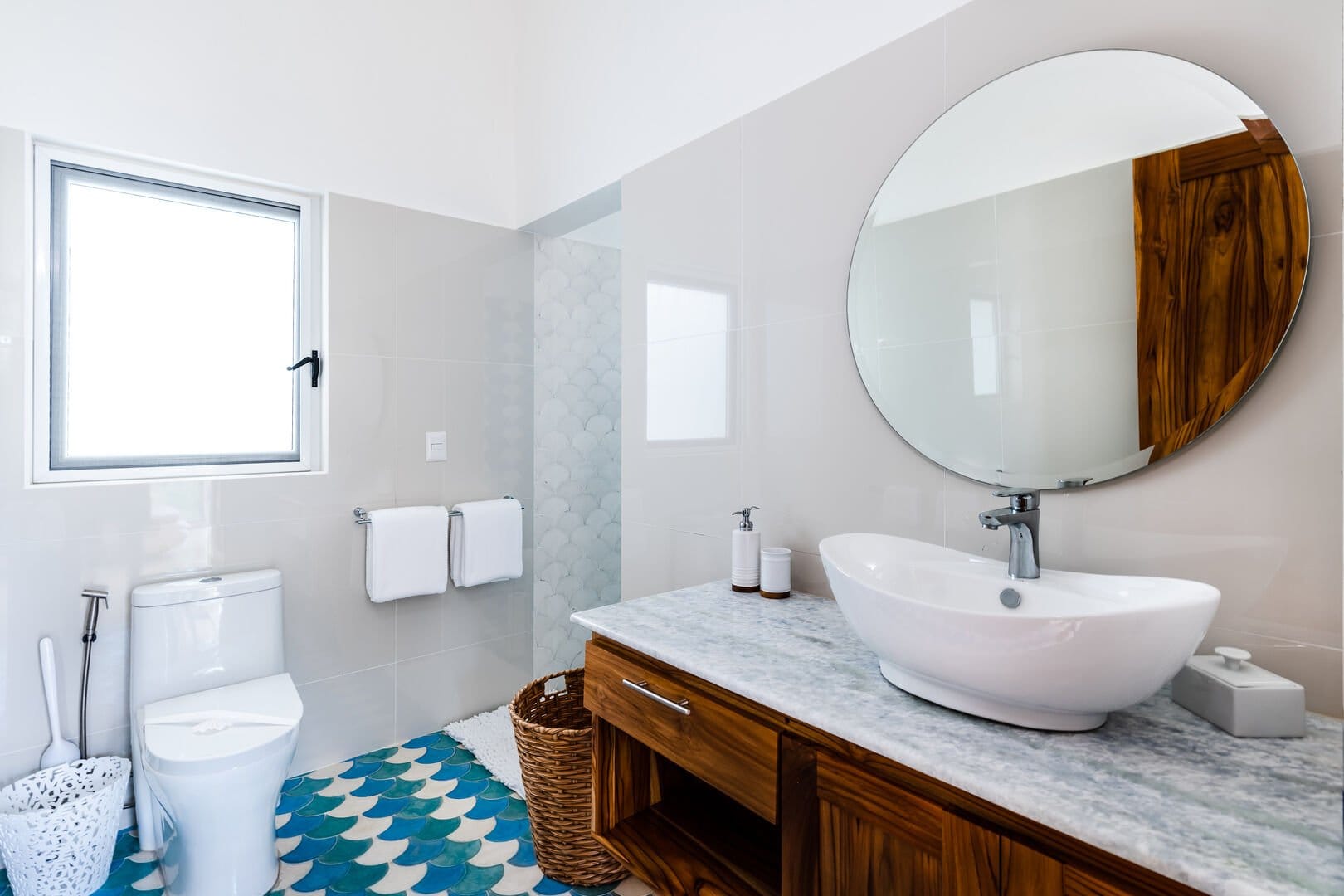 Modern bathroom with large round mirror.