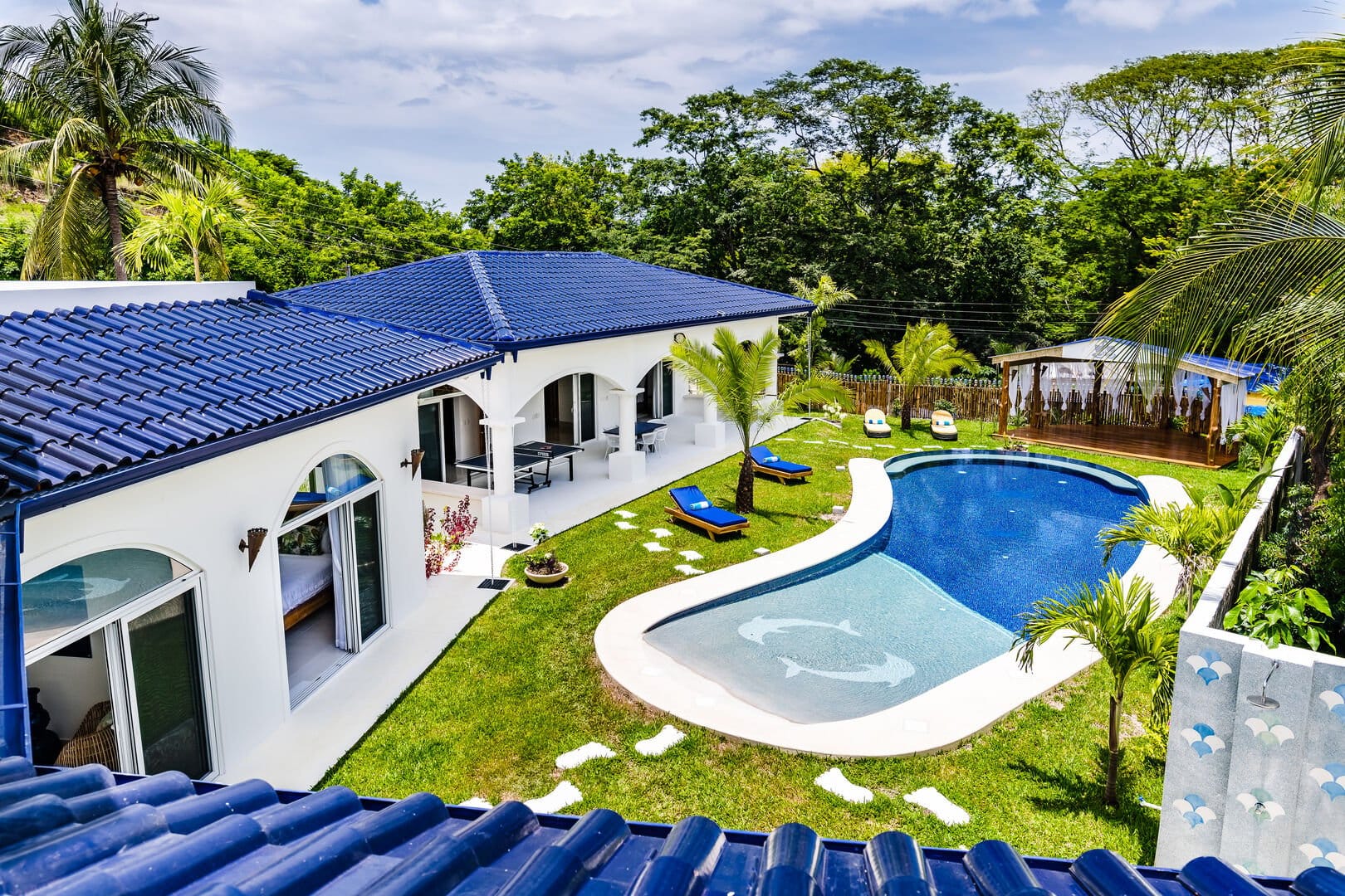 House with pool and palm trees.