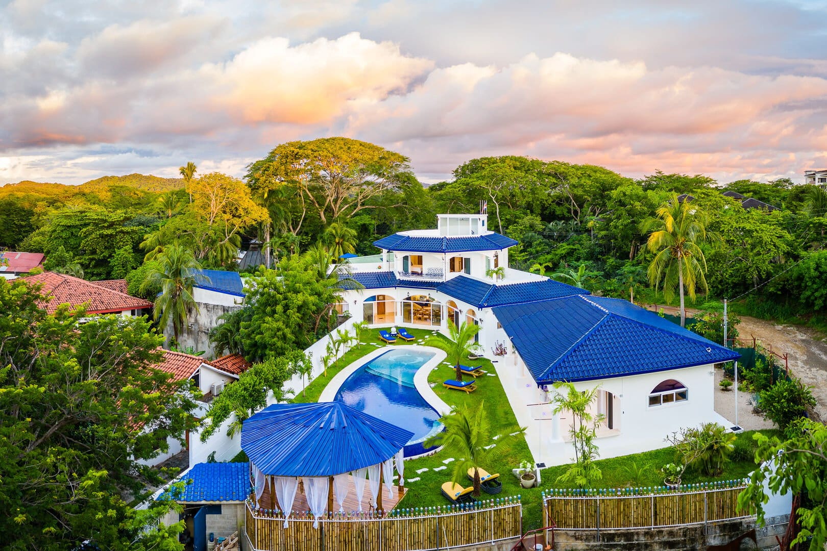Modern villa with pool, lush surroundings.