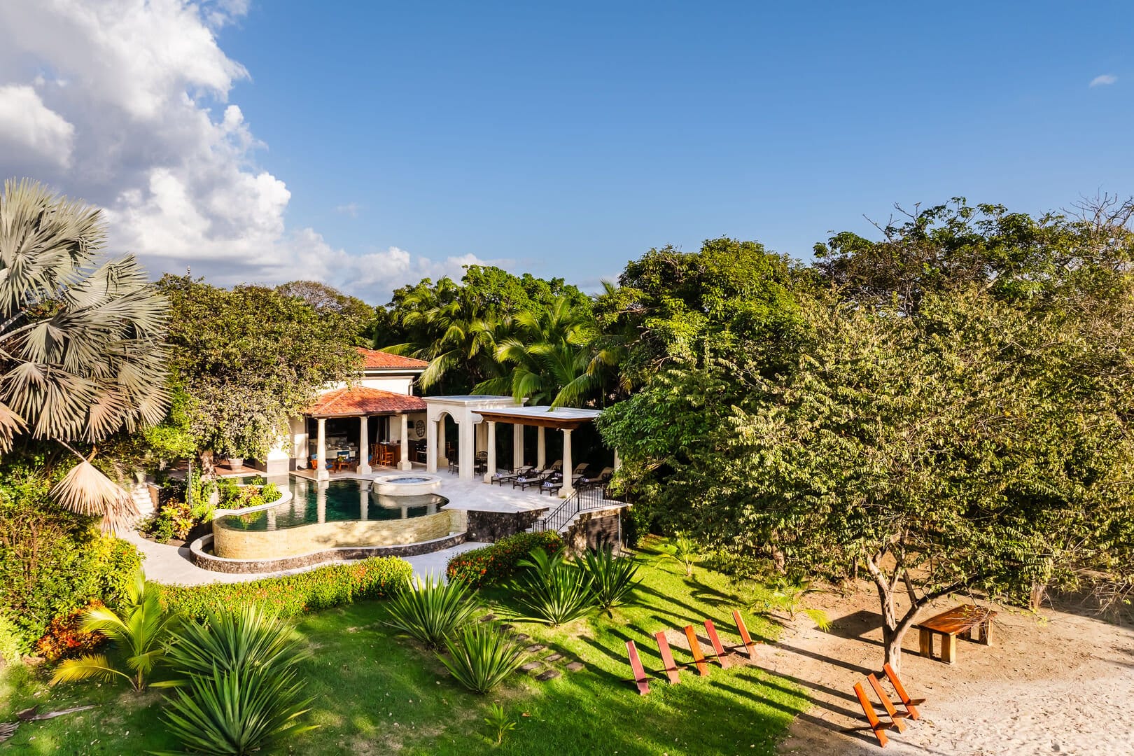 Villa with pool and lush greenery.