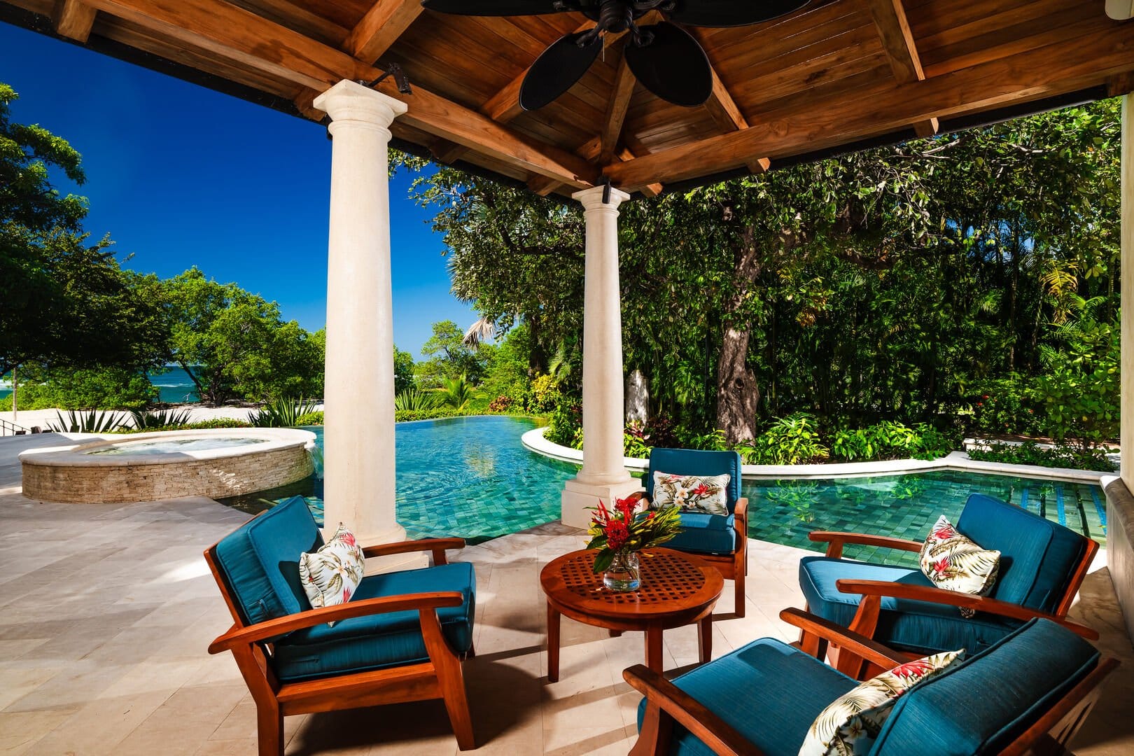 Patio chairs by lush pool.