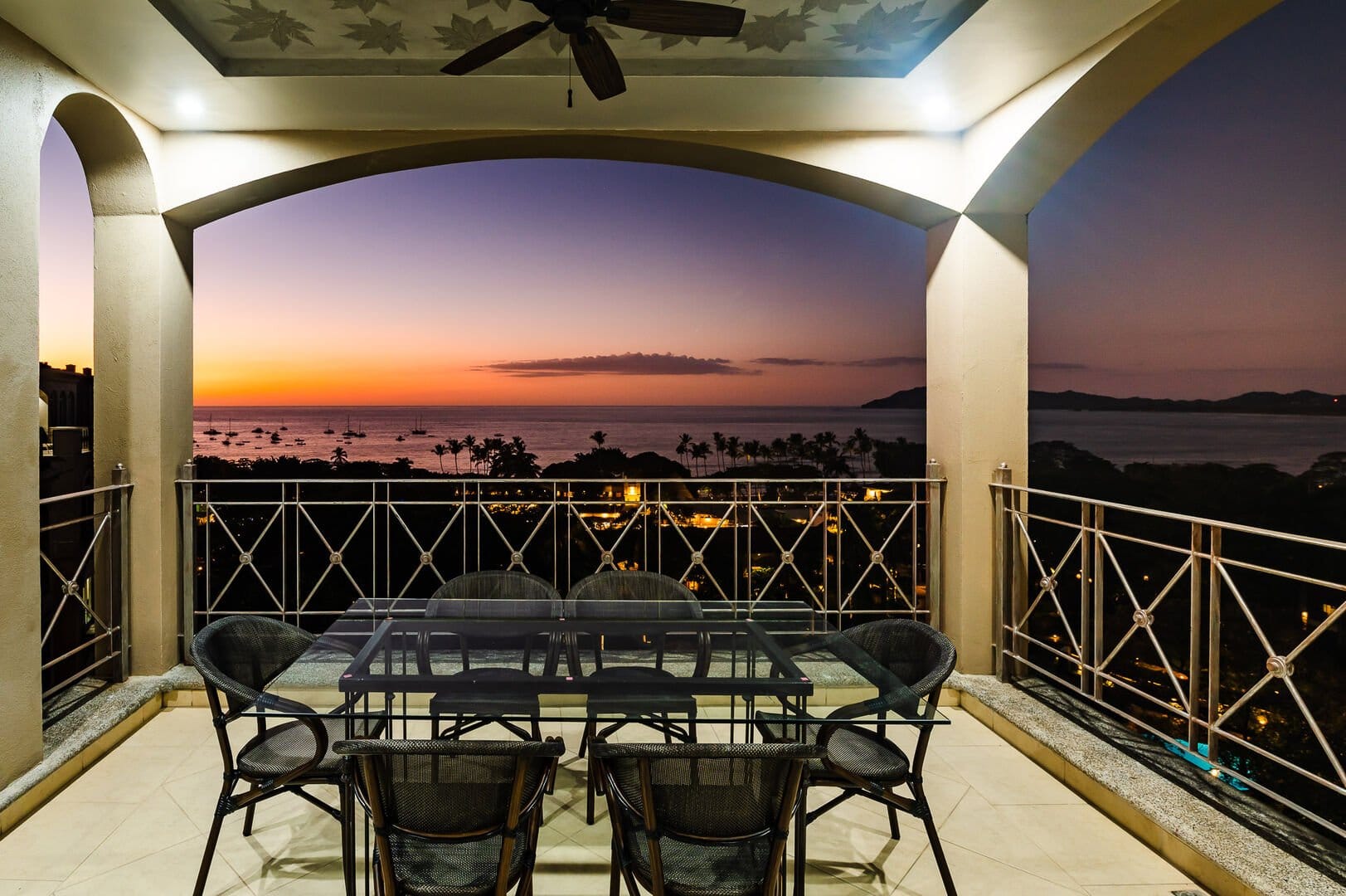 Balcony overlooking ocean at sunset.