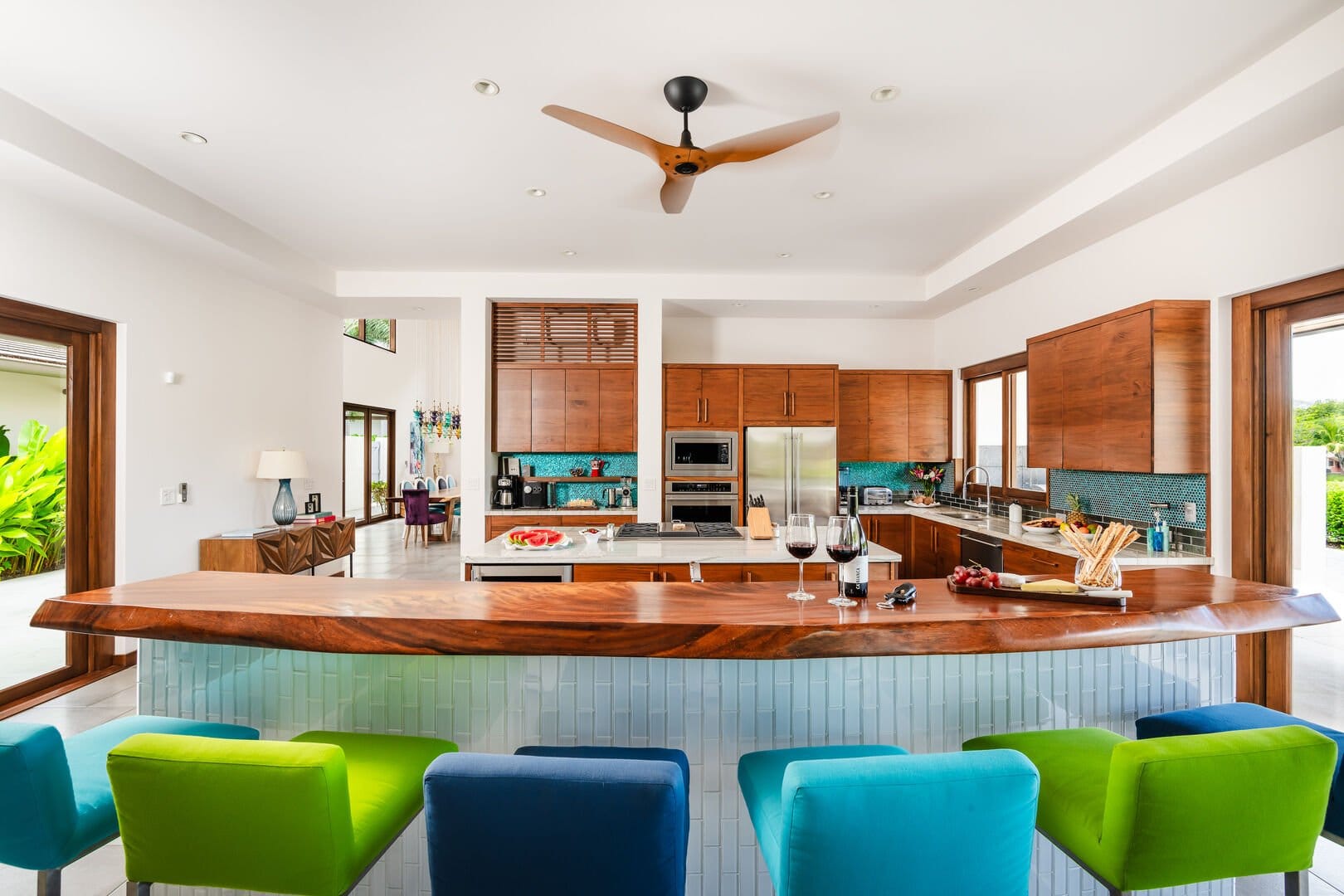Modern kitchen with colorful chairs.
