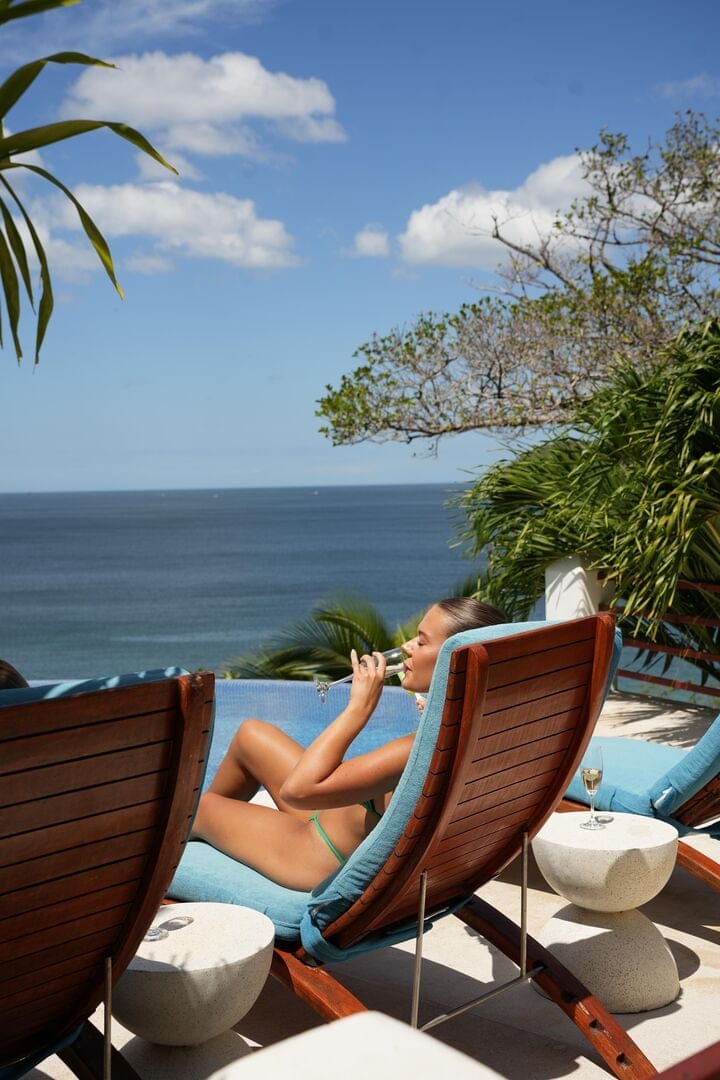 Woman relaxing by ocean, sunbathing.