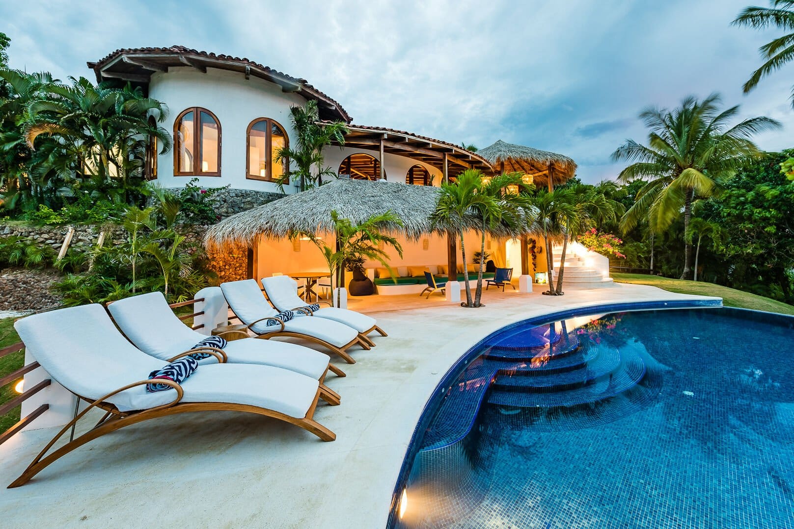 Luxury villa with poolside loungers.