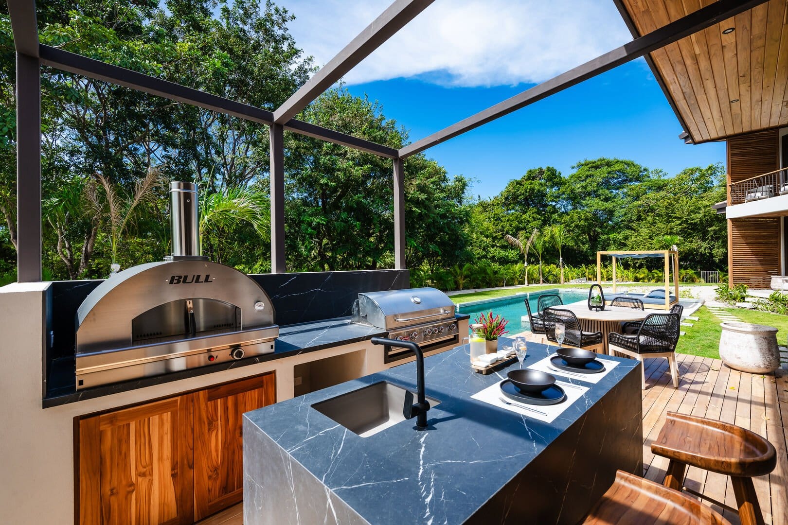 Outdoor kitchen with pool view.
