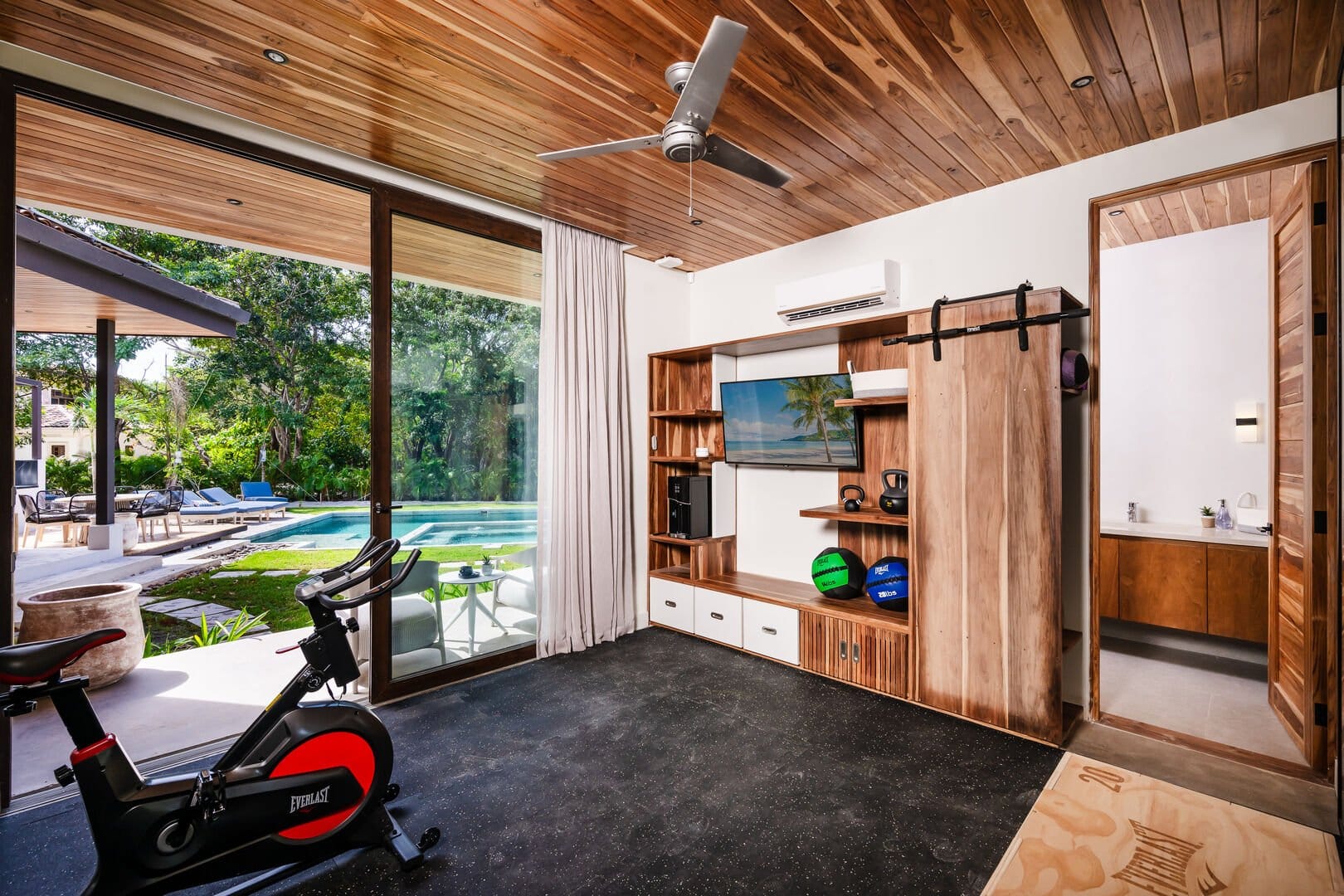 Home gym with pool view.