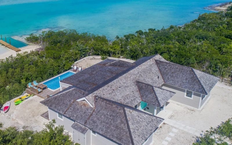 Beachfront house with pool and ocean.