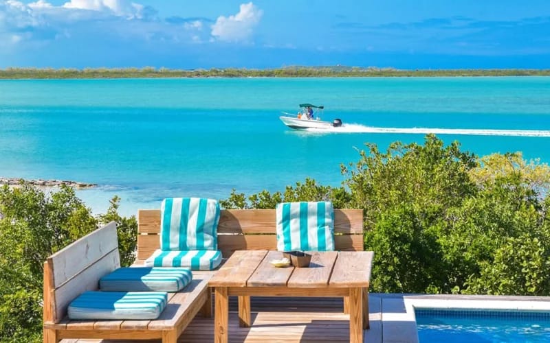 Coastal view with boat, seating area.