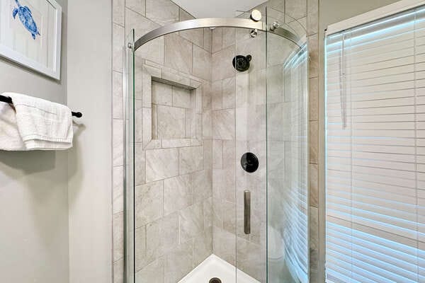 Glass-enclosed corner shower stall.