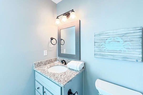 Bathroom with mirror and artwork.