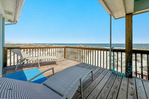 Beachfront deck with lounge chairs.