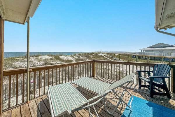 Beachfront deck with lounge chairs.