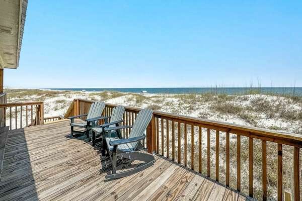 Deck chairs overlooking sandy beach.