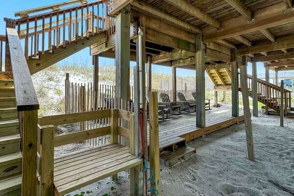 Wooden beach walkway with sand underneath.
