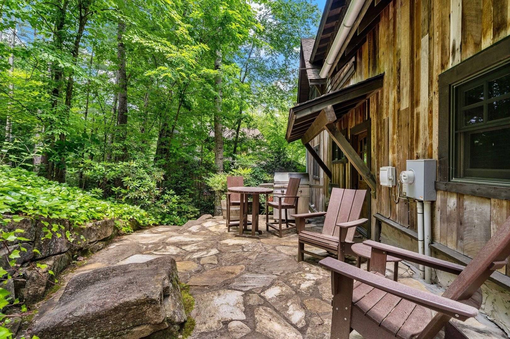 Rustic patio with wooden chairs.