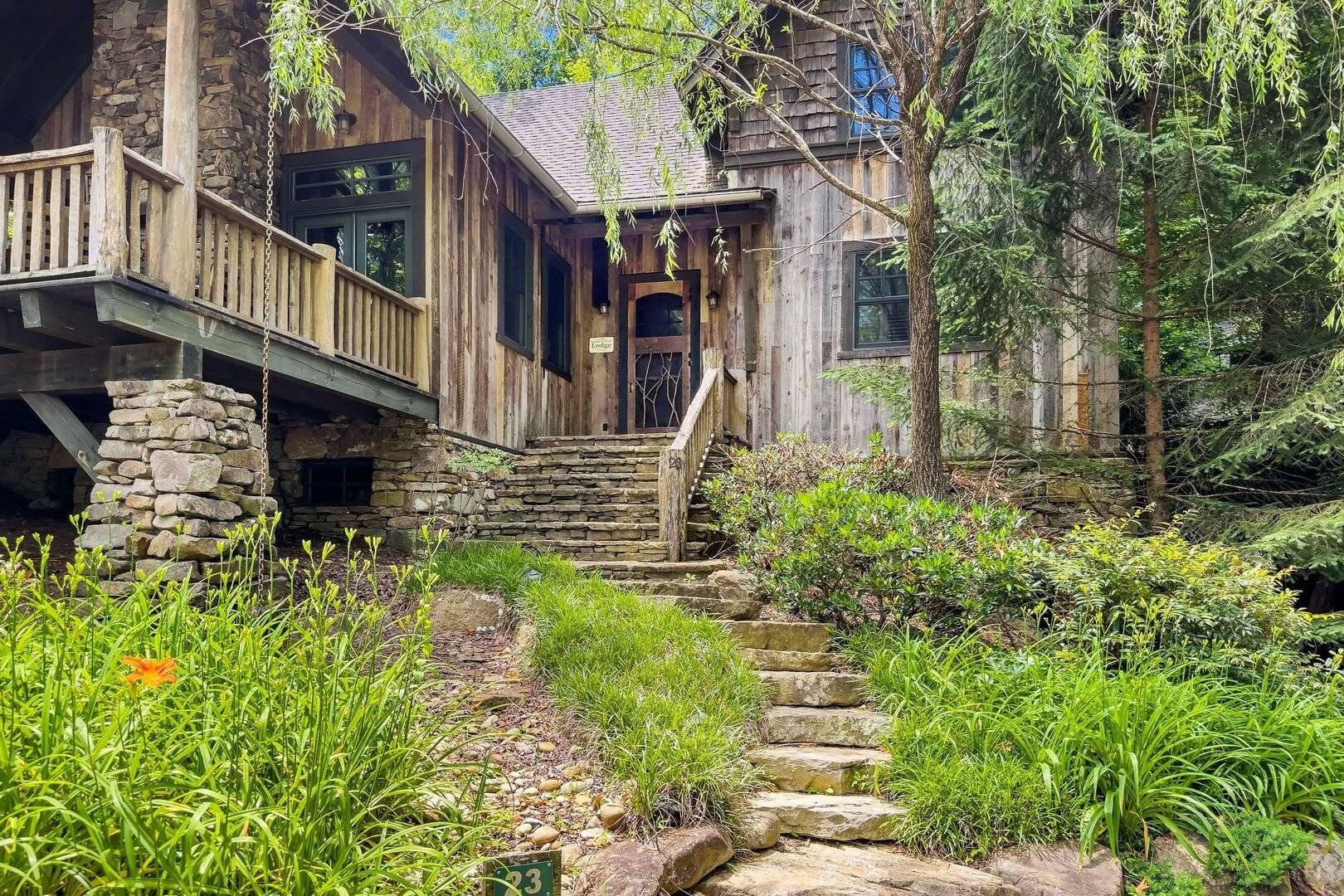 Wooden cabin surrounded by greenery.