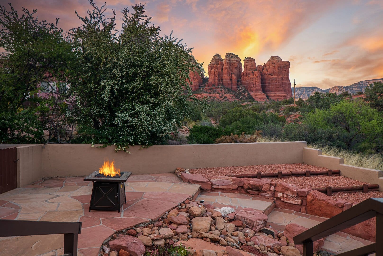 Fire pit on stone patio, sunset.