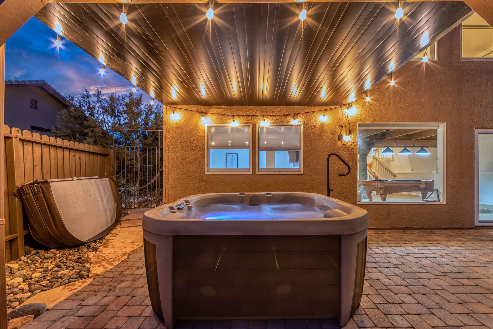 Outdoor hot tub with string lights.
