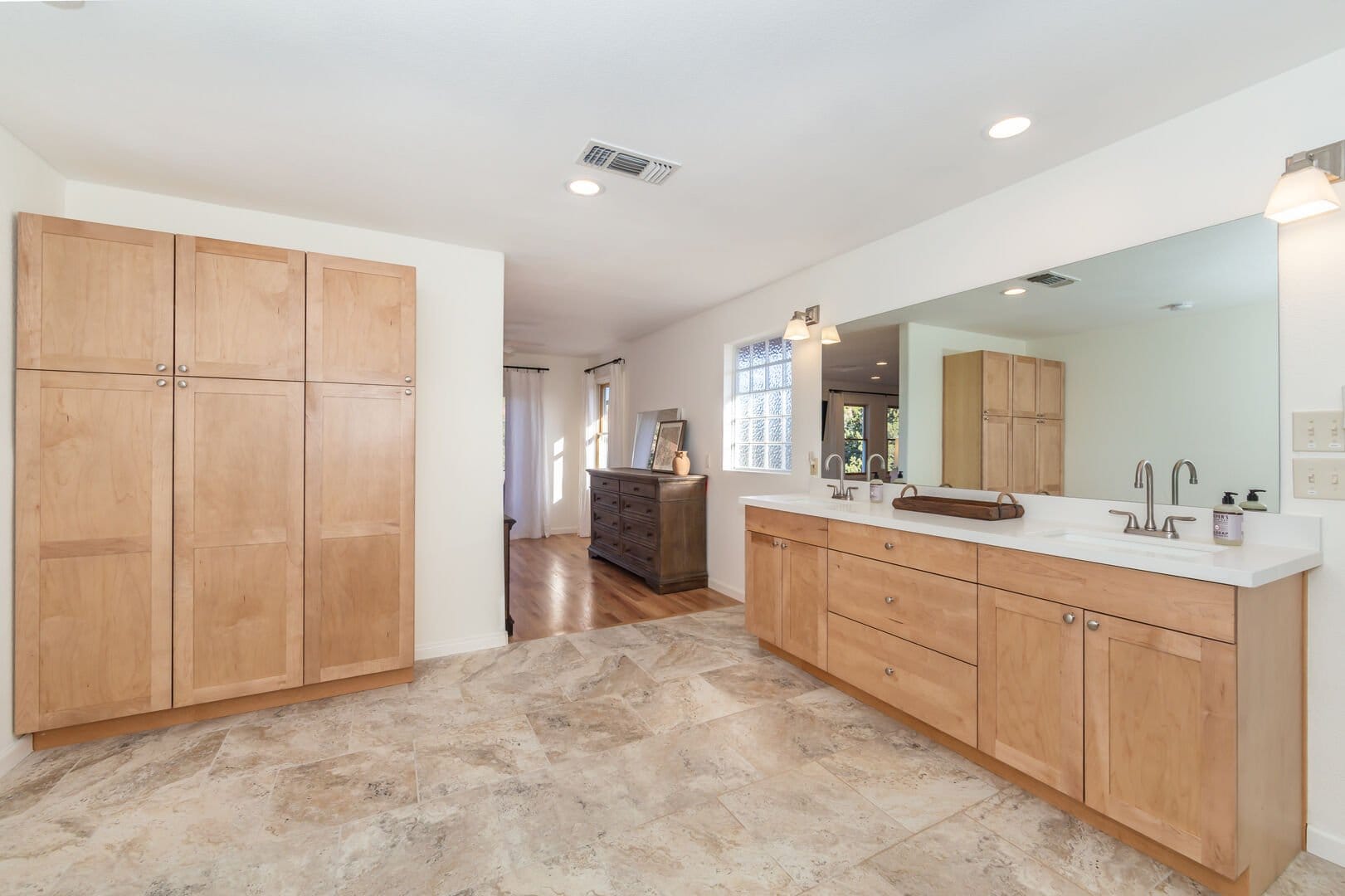 Bathroom with wooden cabinets, mirror.