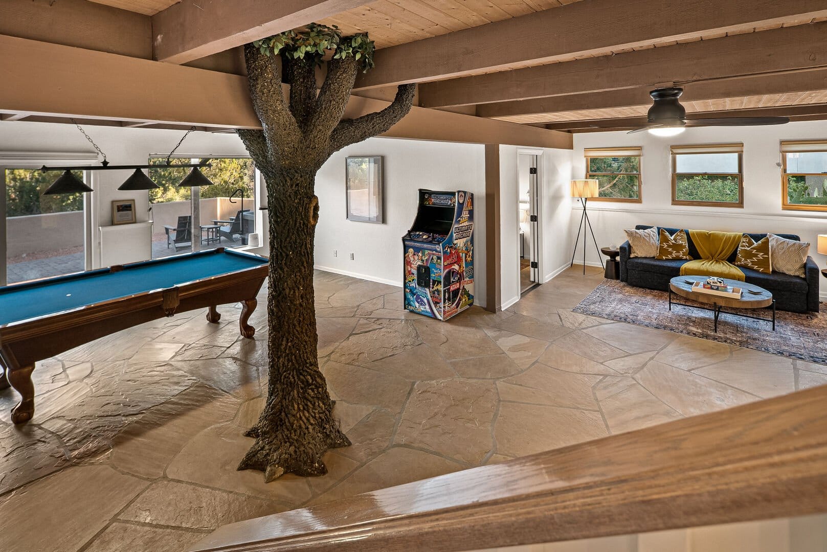 Spacious room with tree, pool table.