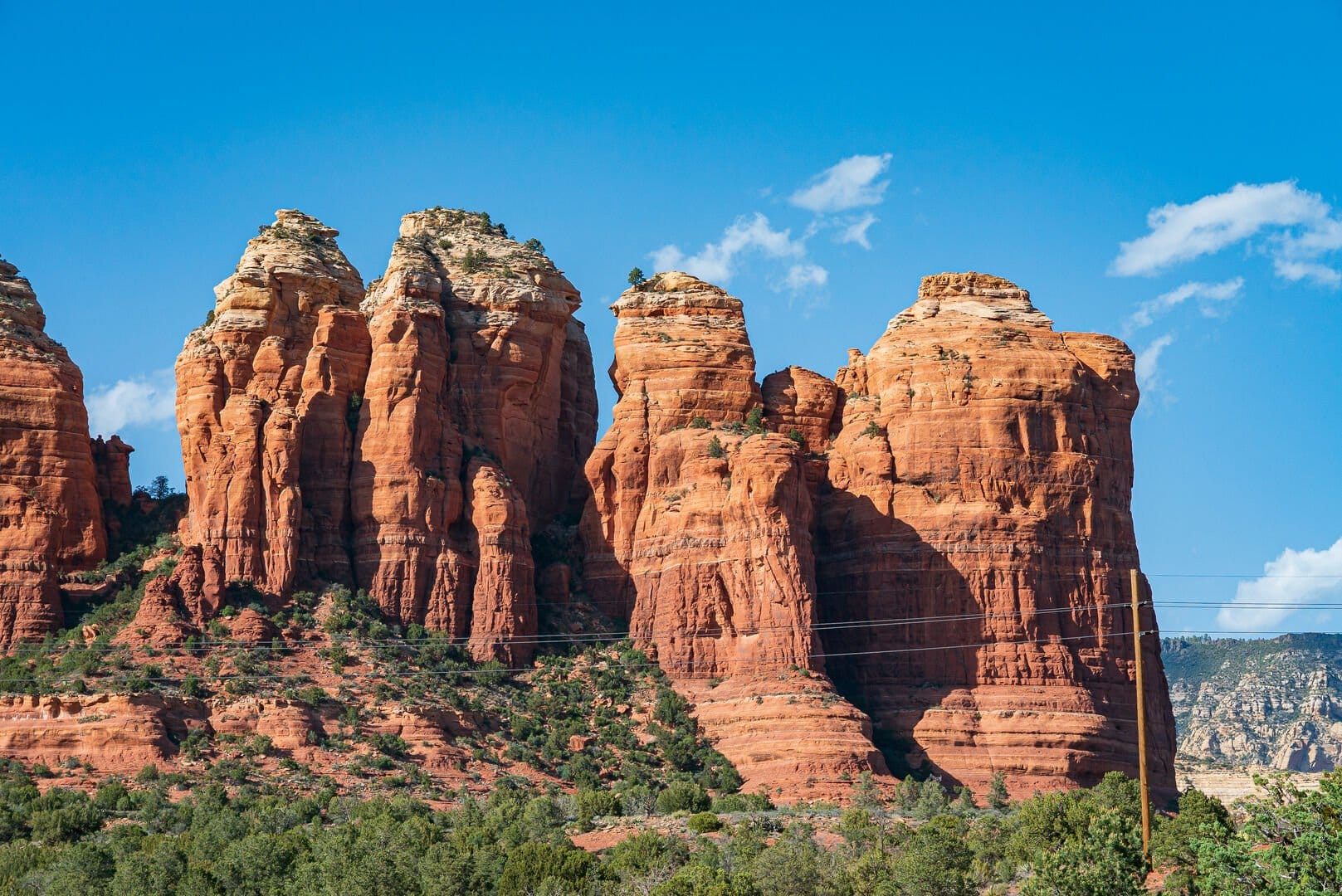 Red rock formations under blue sky.