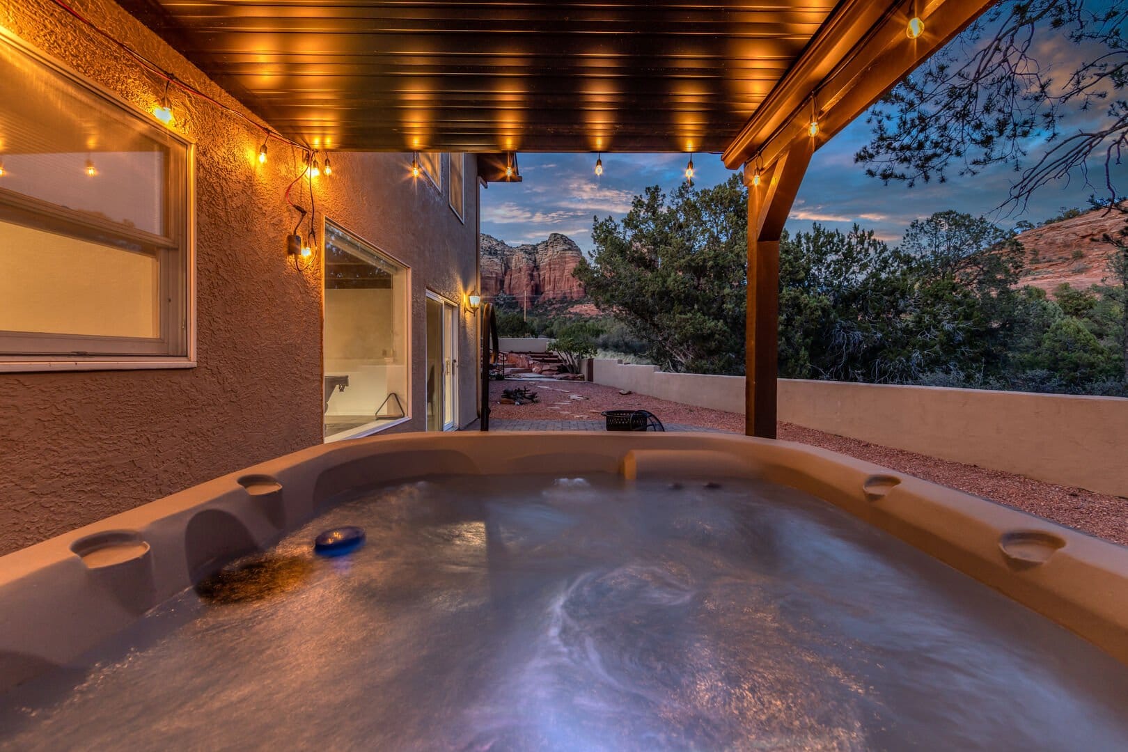 Outdoor hot tub with string lights.