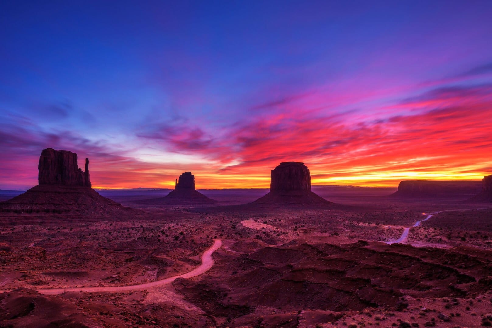 Monument Valley sunrise, vibrant sky.