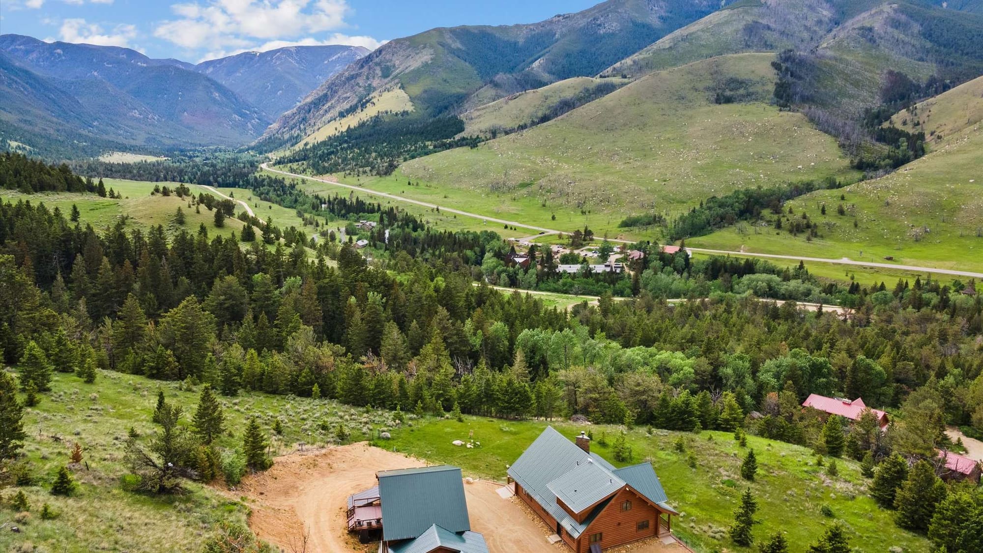 Mountain valley landscape with cabins.