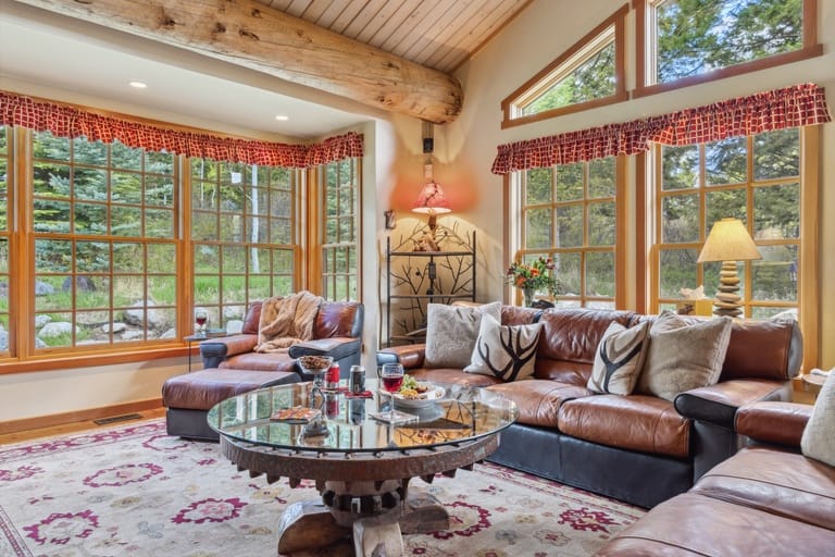 Cozy rustic living room, large windows.