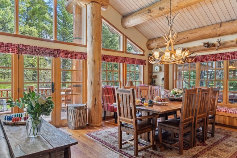 Rustic dining room with large windows.