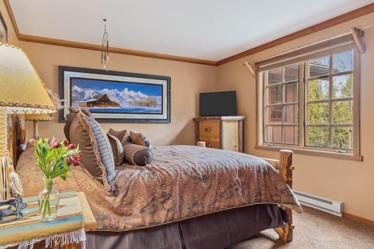 Rustic bedroom with mountain artwork.