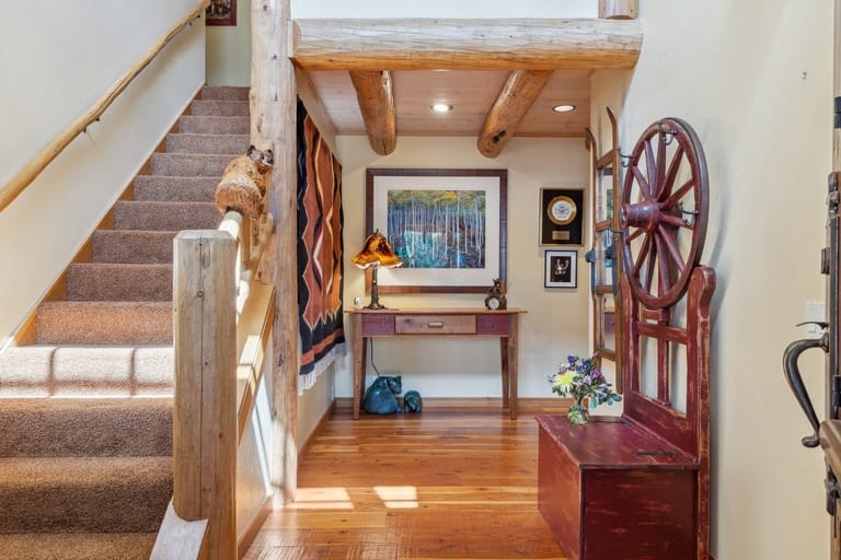 Rustic hallway with staircase, bench.