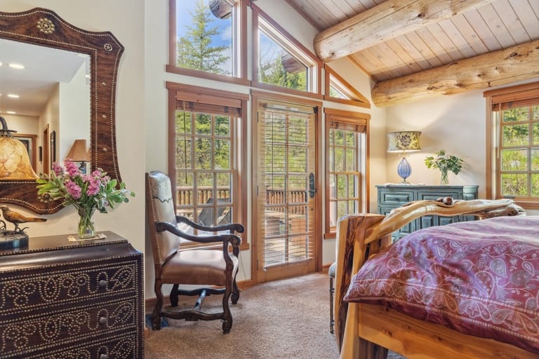 Rustic bedroom with large windows.