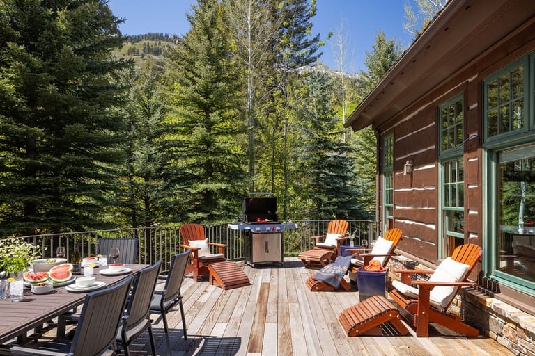 Wooden deck with chairs, grill.