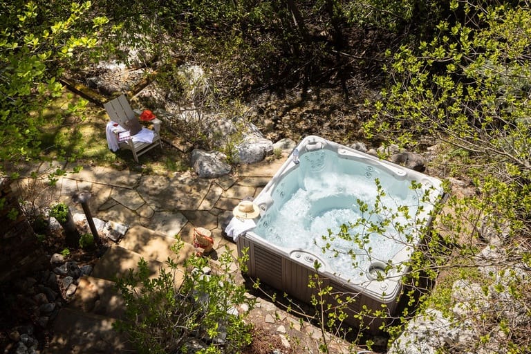 Backyard hot tub amidst lush greenery.