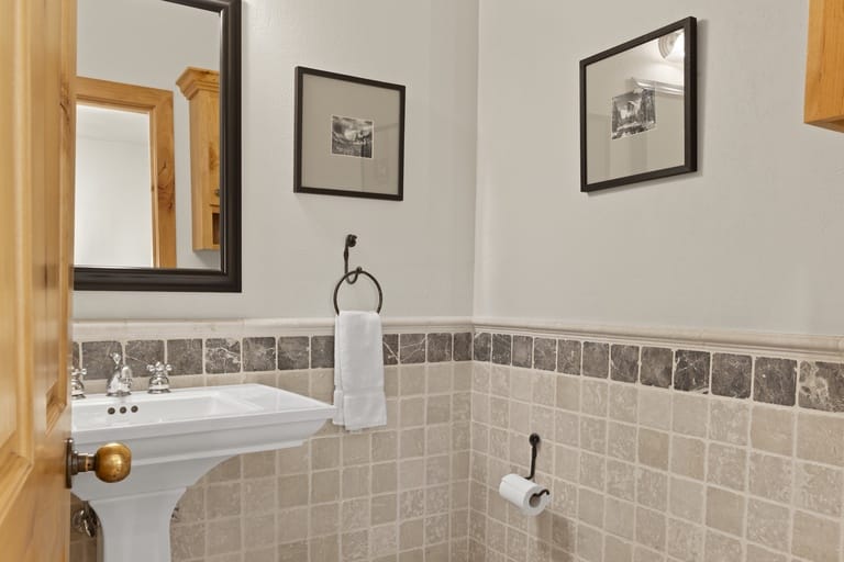 Tiled bathroom with sink and artwork.