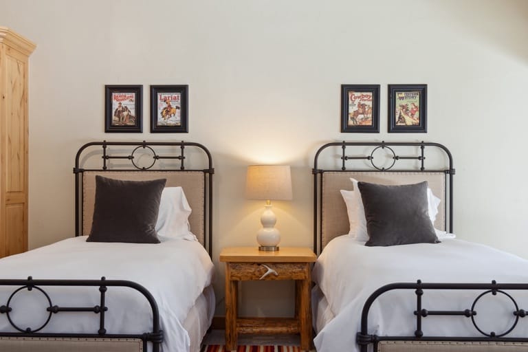 Two beds, bedside table, wall art.