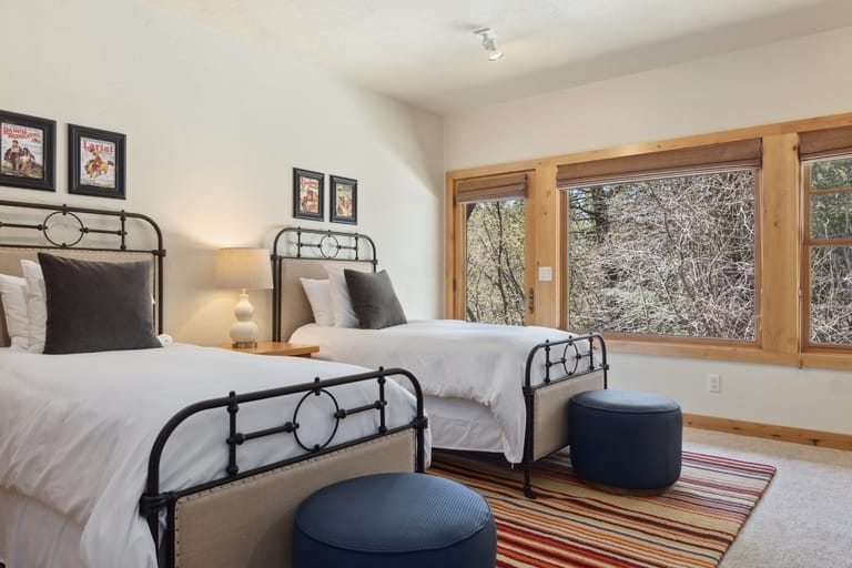 Twin beds, rustic room, large window.