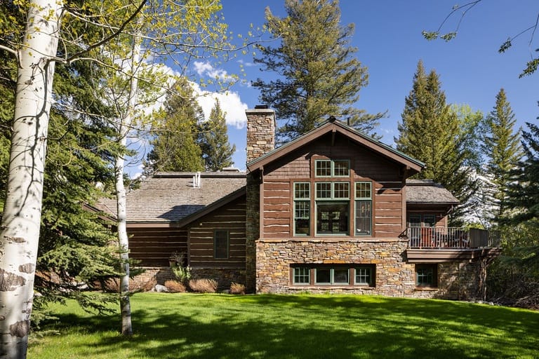 Cabin in forest with chimney.