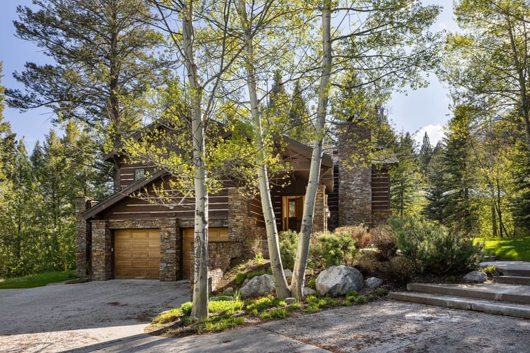Rustic house surrounded by trees.