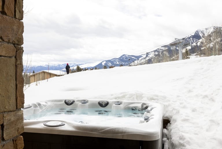 Outdoor hot tub in snowy mountains.