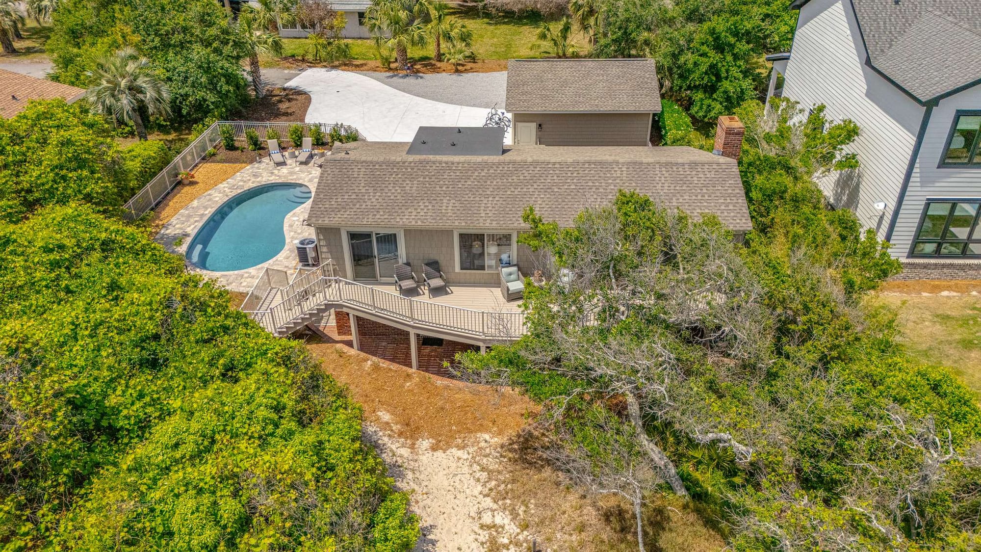House with pool and surrounding trees.