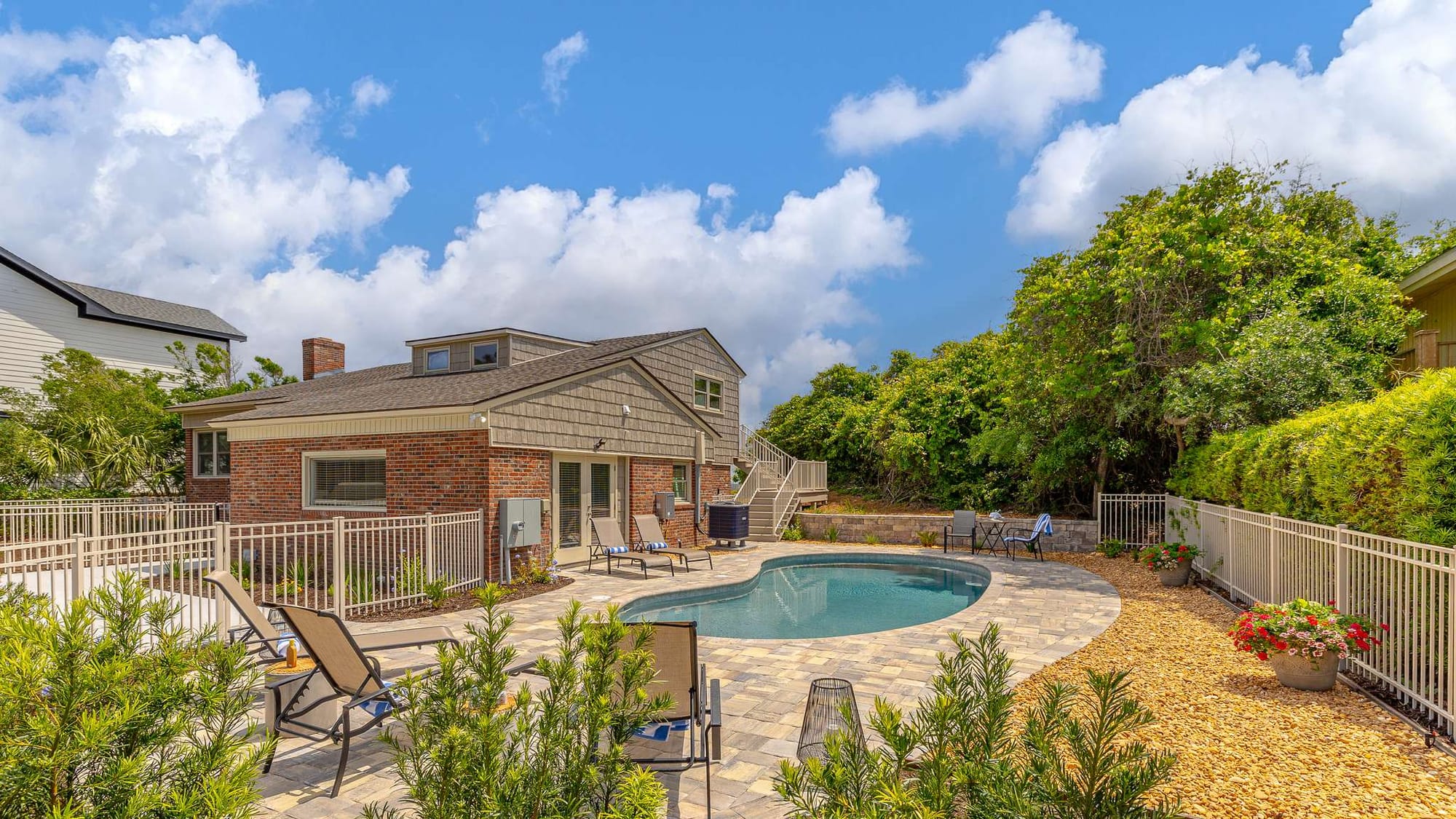 Backyard pool with patio chairs.