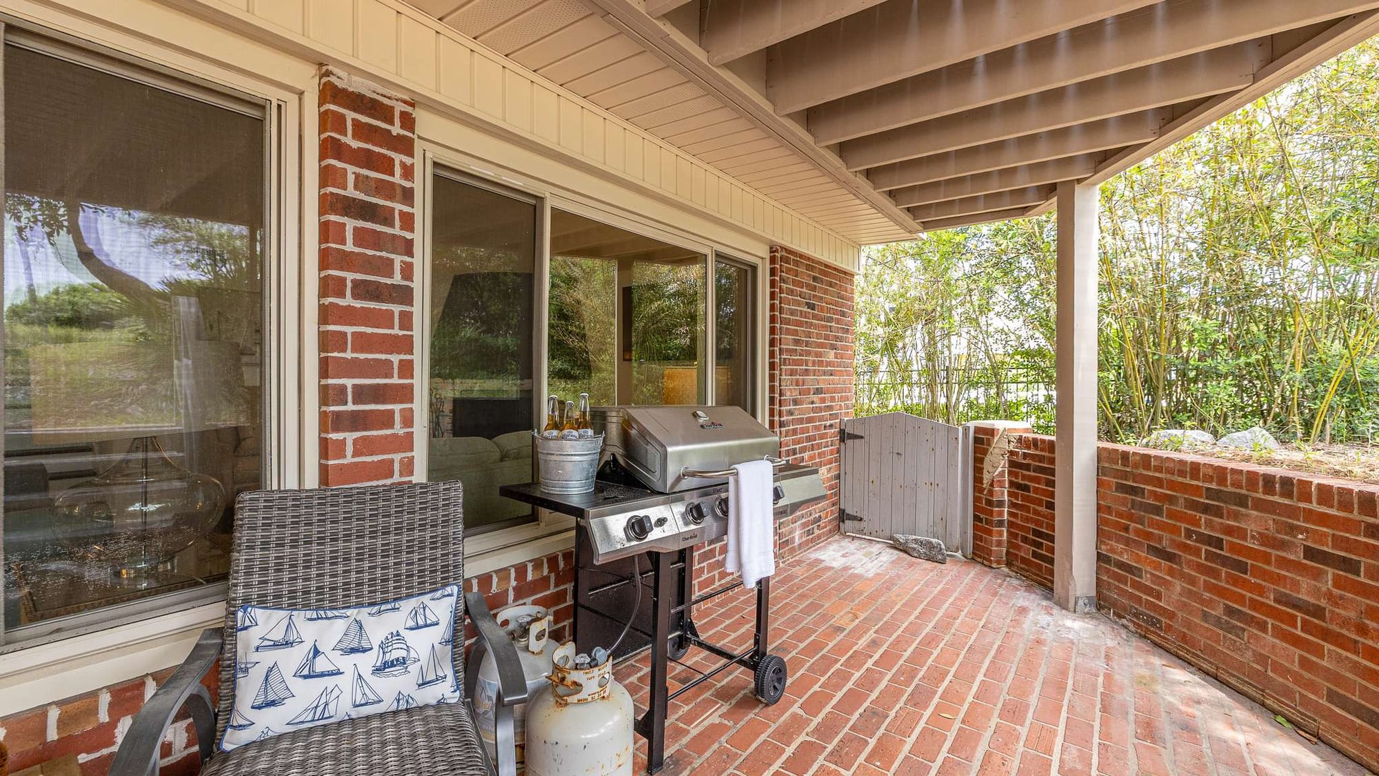 Outdoor patio with grill and chair.